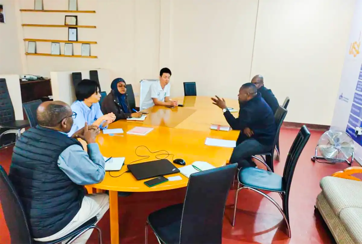 A group of people in discussion around a meeting table.