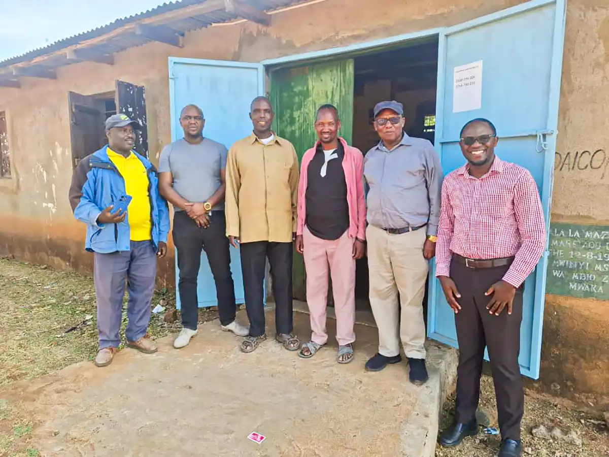 A group of people standing outside a blue-doored building.
