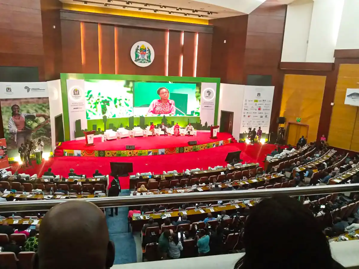 A large conference hall with a stage and seated audience.
