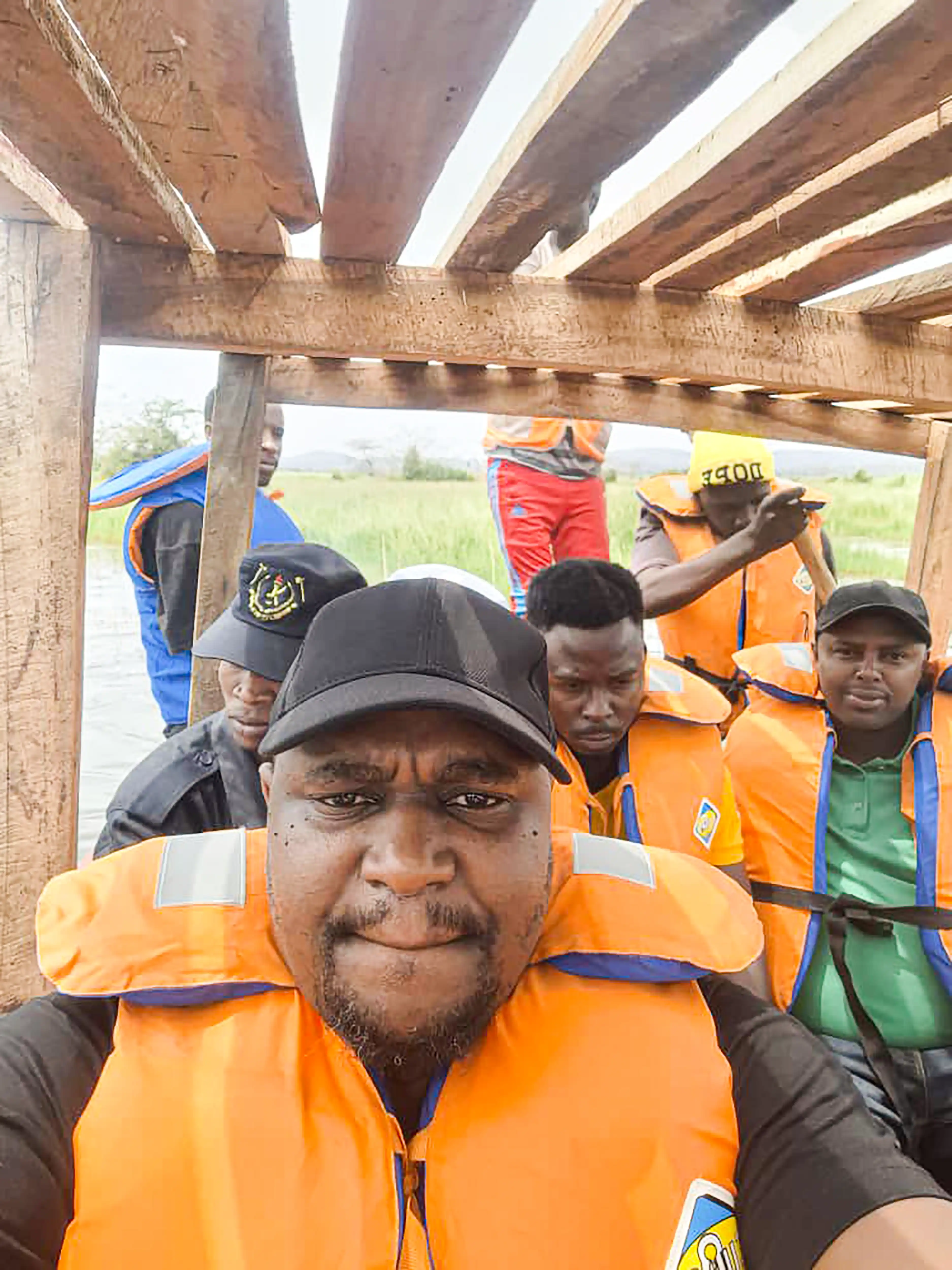 A close group selfie; several people wear bright safety vests.